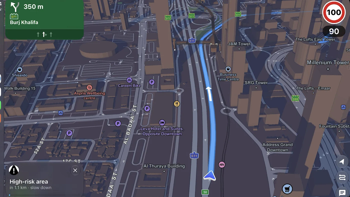 CarPlay lane guidance: green sign for Burj Khalifa in 350 m with an arrow for each lane, a 100 km/h limit and a card, high-risk area in 1.1 km